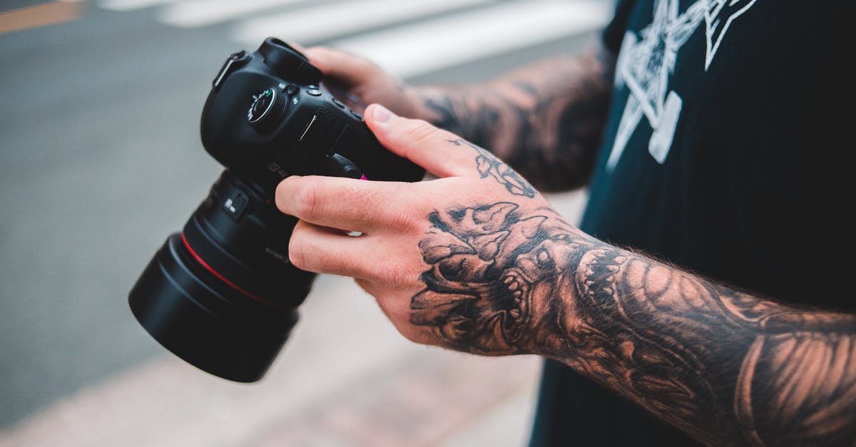 Is there a setting for slowly killing units that are outside a city or military base? - Unrecognizable man with tattoos on arms standing on blurred street near crosswalk with professional photo camera in hands in city