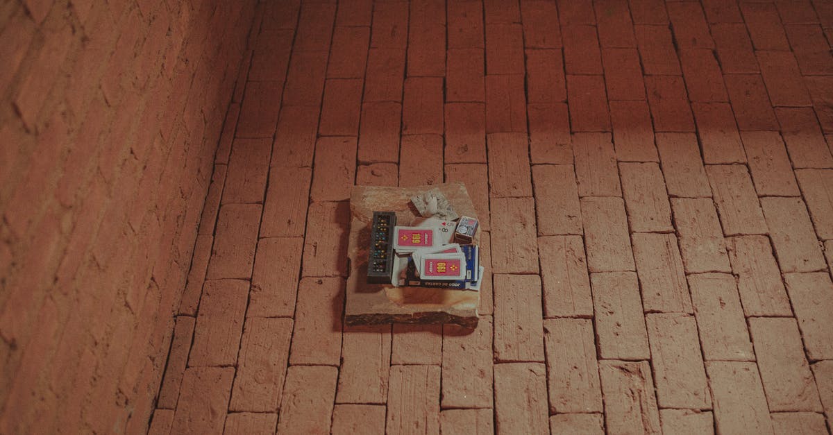 Is there a term for a non-ftp electronic deck-building card game (a CCG without the first C)? - From above of domino and card decks placed together with matches on brick aged pavement