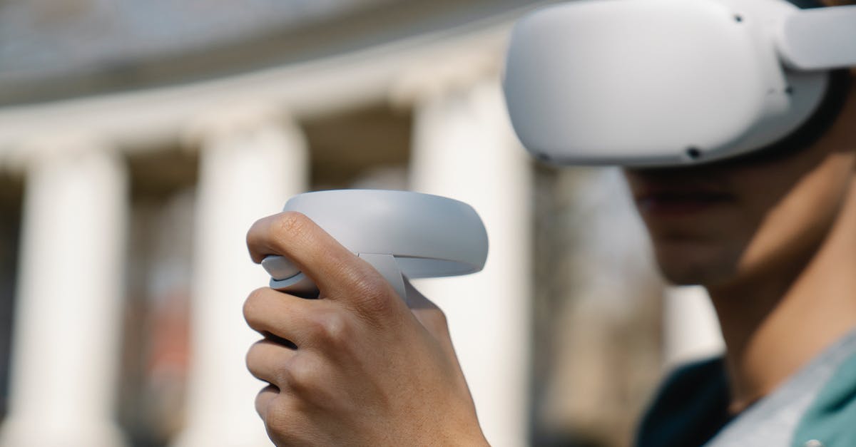 Is there a term for a non-ftp electronic deck-building card game (a CCG without the first C)? - Crop young male in modern goggles of virtual reality using controllers while standing near building on street on daytime