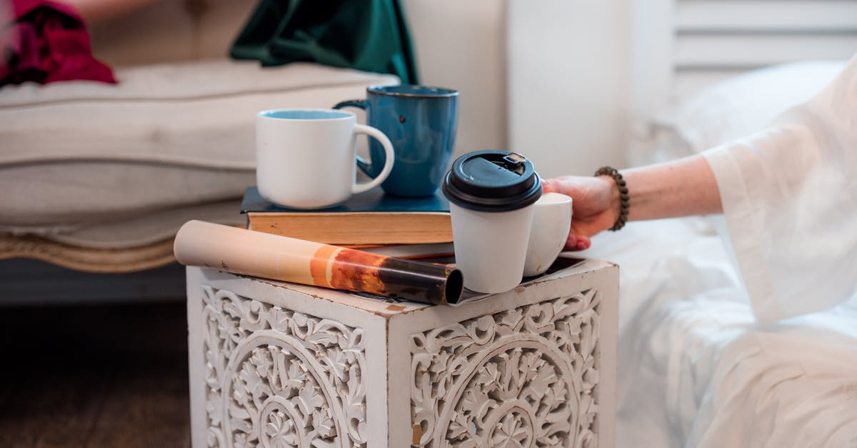 Is there a use for burnt books or magazines? - A Person Putting a Ceramic Cup on the Coffee table