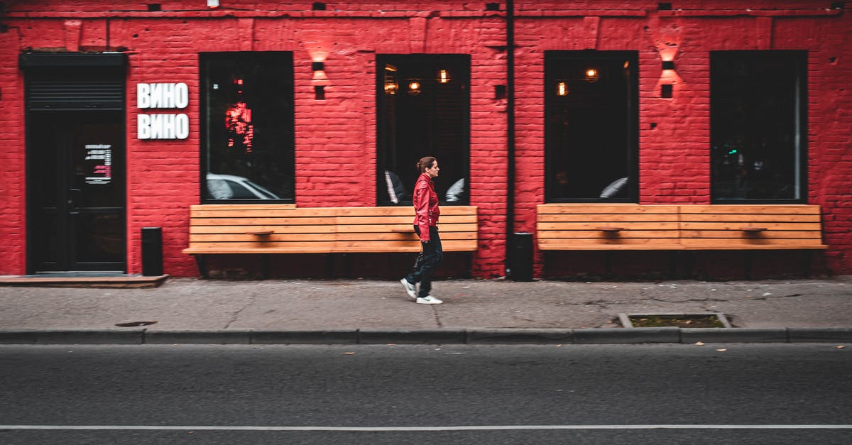 Is there a way I can store variables in my Minecraft world? - Side view of modern female walking on sidewalk near red building on city street