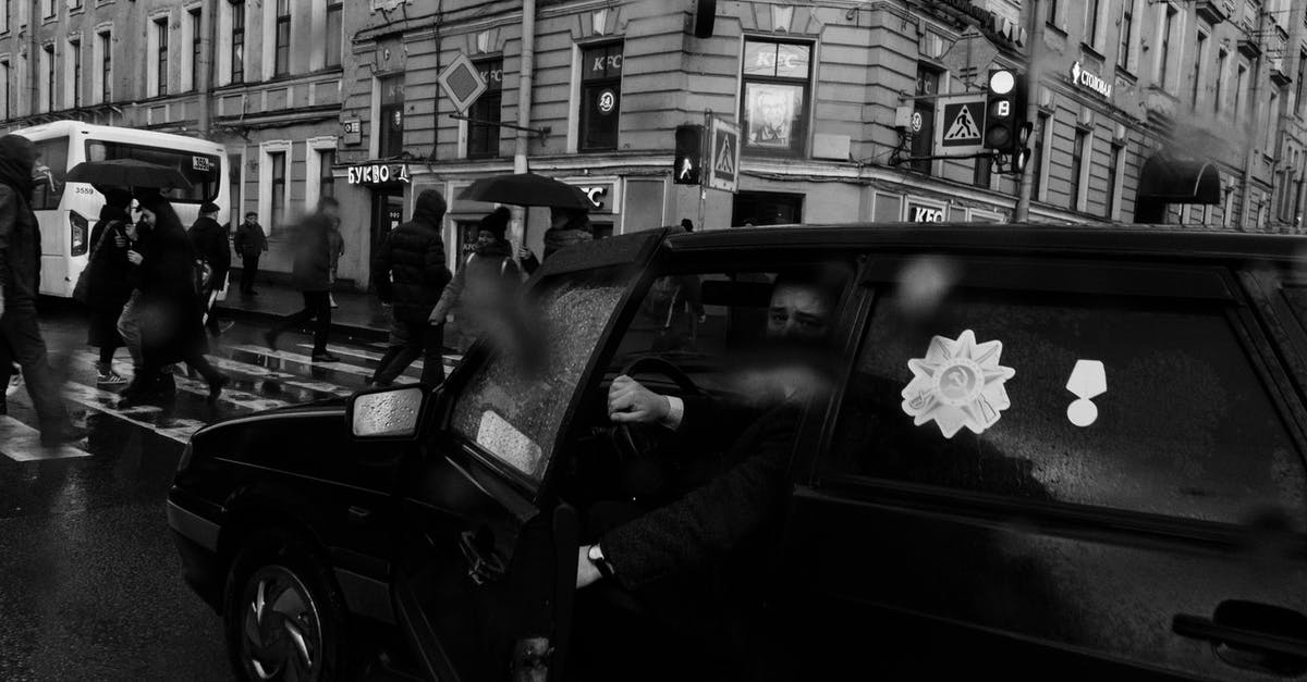 Is there a way to bet more than 9999 medals? - Man in black car with medal stickers stopped near crosswalk