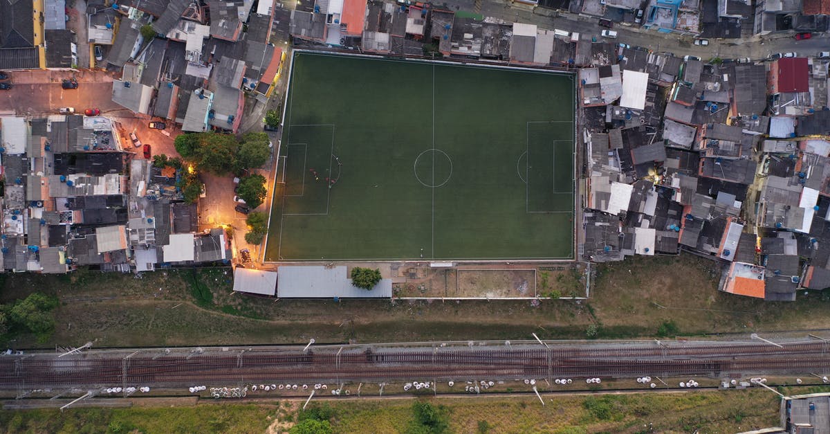 Is there a way to completely pause the game? - Aerial view of football field surrounded by small typical residential houses in city outskirts near road