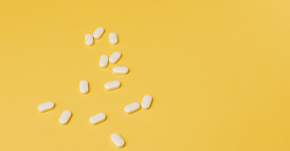 Is there a way to cure poison? - From above of small white ellipse shaped pills of same size randomly placed on bright yellow background
