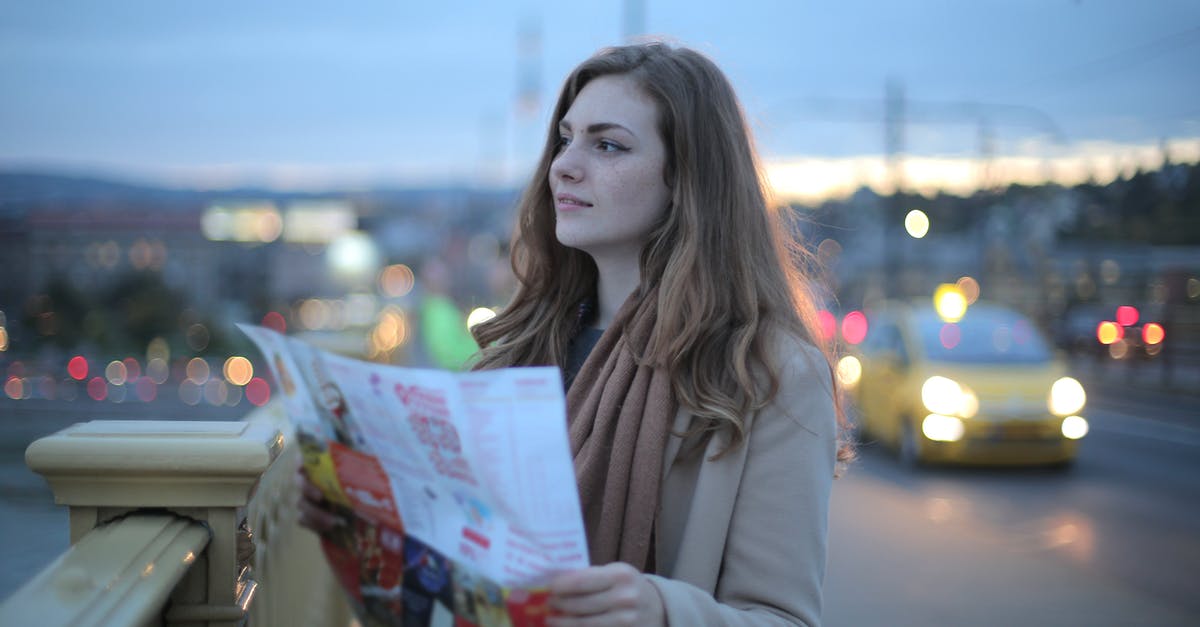 Is there a way to disable global warming and nuclear winter once the game has started? - Female traveler in warm clothes standing on street with map and looking away at dusk