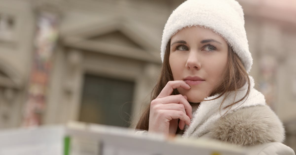 Is there a way to disable global warming and nuclear winter once the game has started? - Concentrated female in warm hat and coat looking for right way while standing with map in street