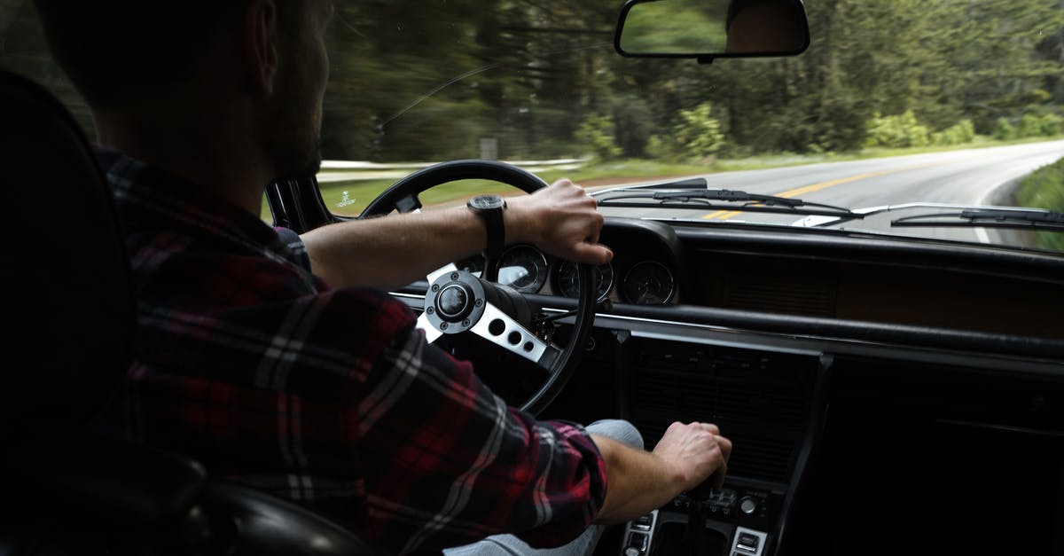 Is there a way to increase movement speed? - Back view of crop anonymous male driver in casual outfit in contemporary car riding along asphalt road through forest in daytime