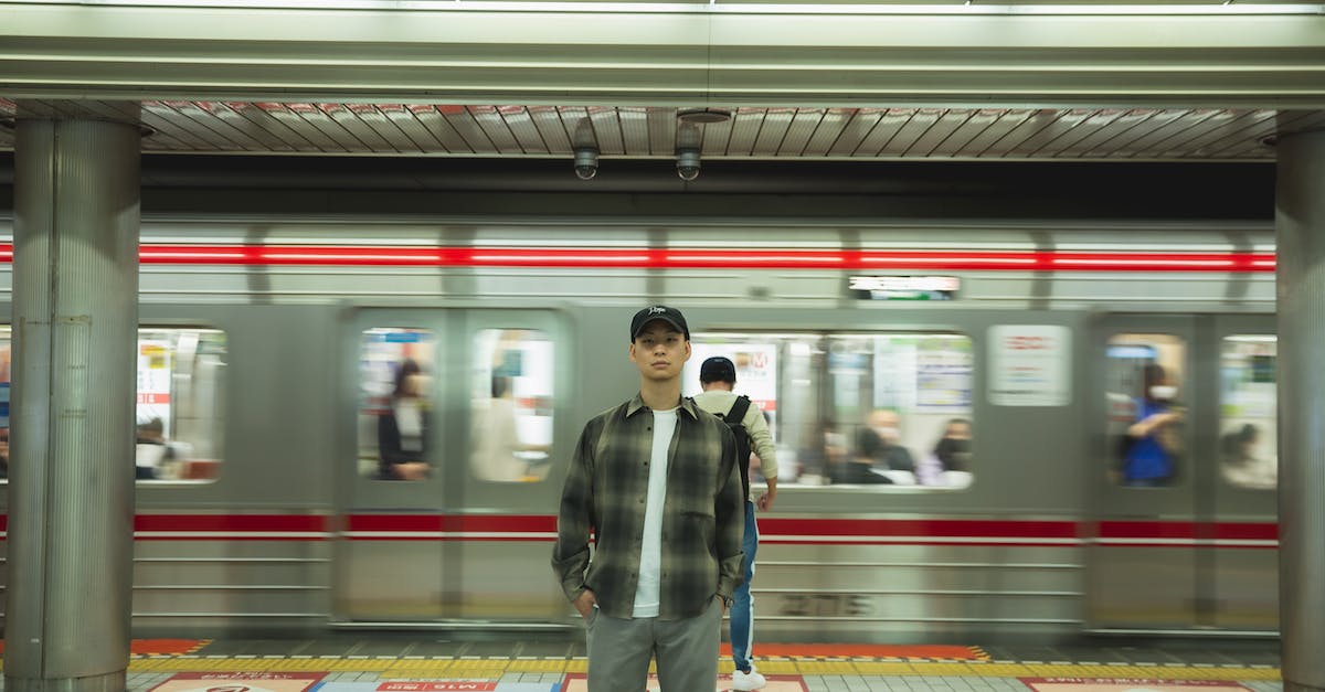 Is there a way to increase the weekly caps? - Asian man standing on platform in underground