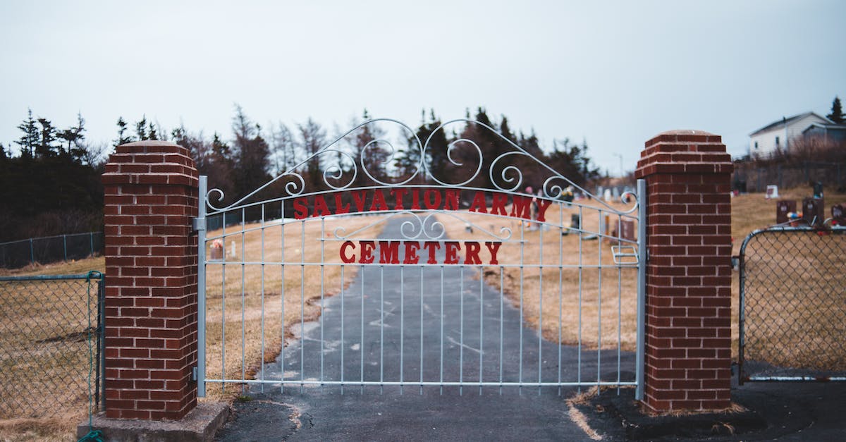 Is there a way to kill charged enemy soldiers without the REC? - Countryside road and closed entrance to army cemetery with metal bars on gloomy day