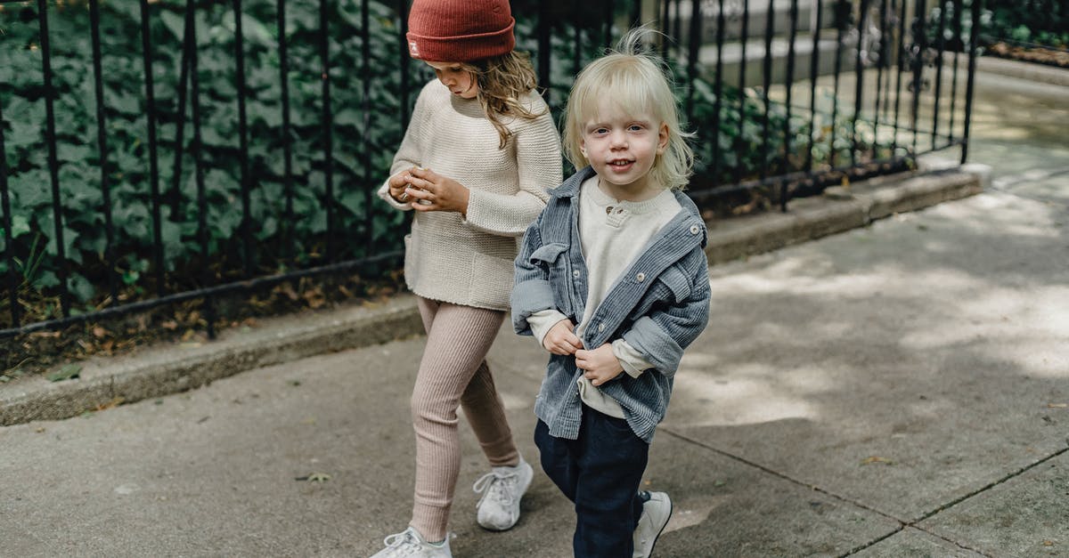 Is there a way to not change camera angles? - Cheerful siblings walking on sidewalk Is there a way to not change camera angles? - Cheerful siblings walking on sidewalk