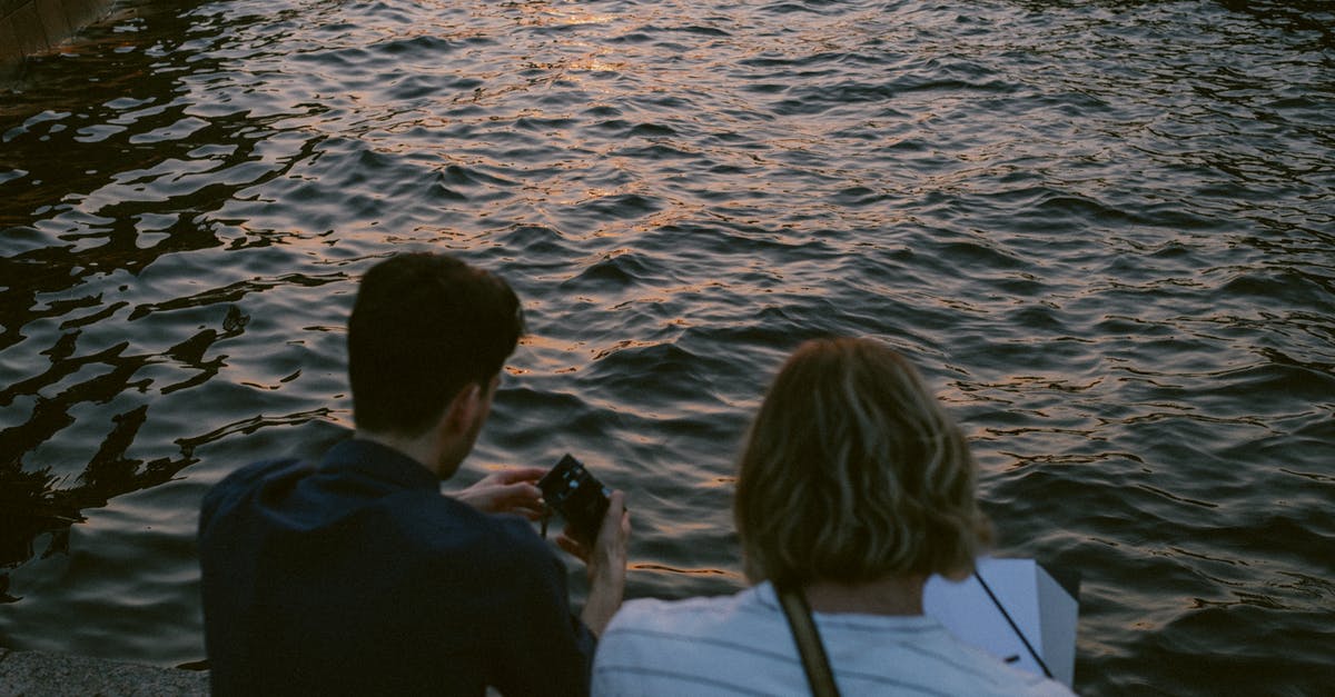 Is there a way to not change camera angles? - Two Men Sitting on Concrete Dock Holding Camera and Paper