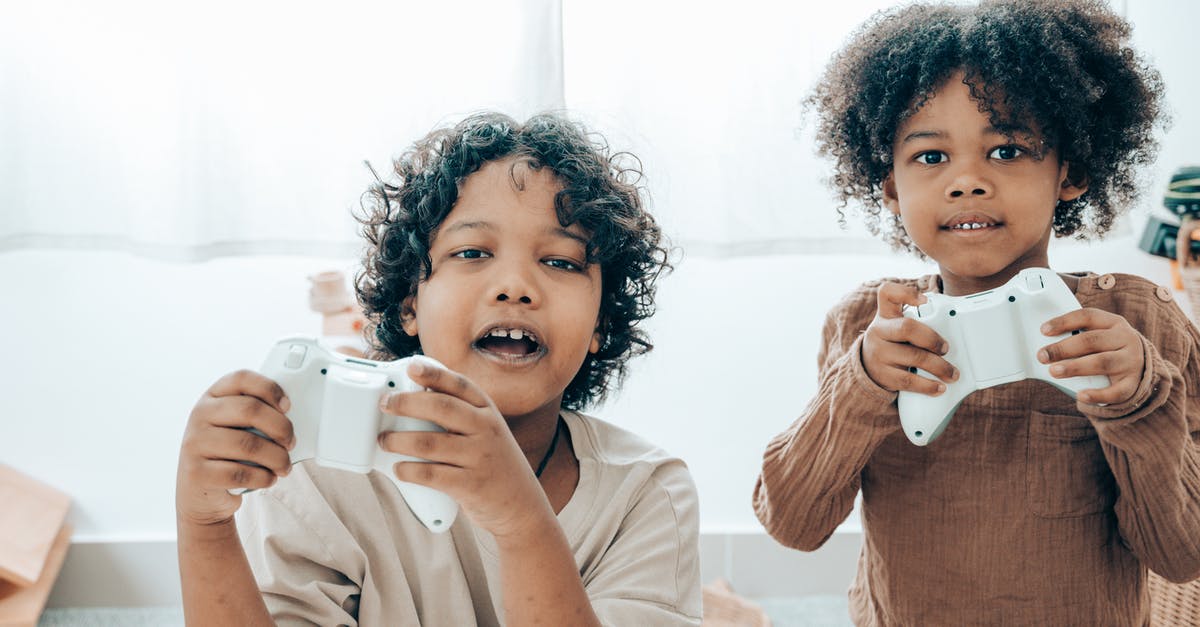 Is there a way to play Minecraft with a friend using "open to LAN" while not on the same network? [duplicate] - Cheerful black children playing with game pads in room