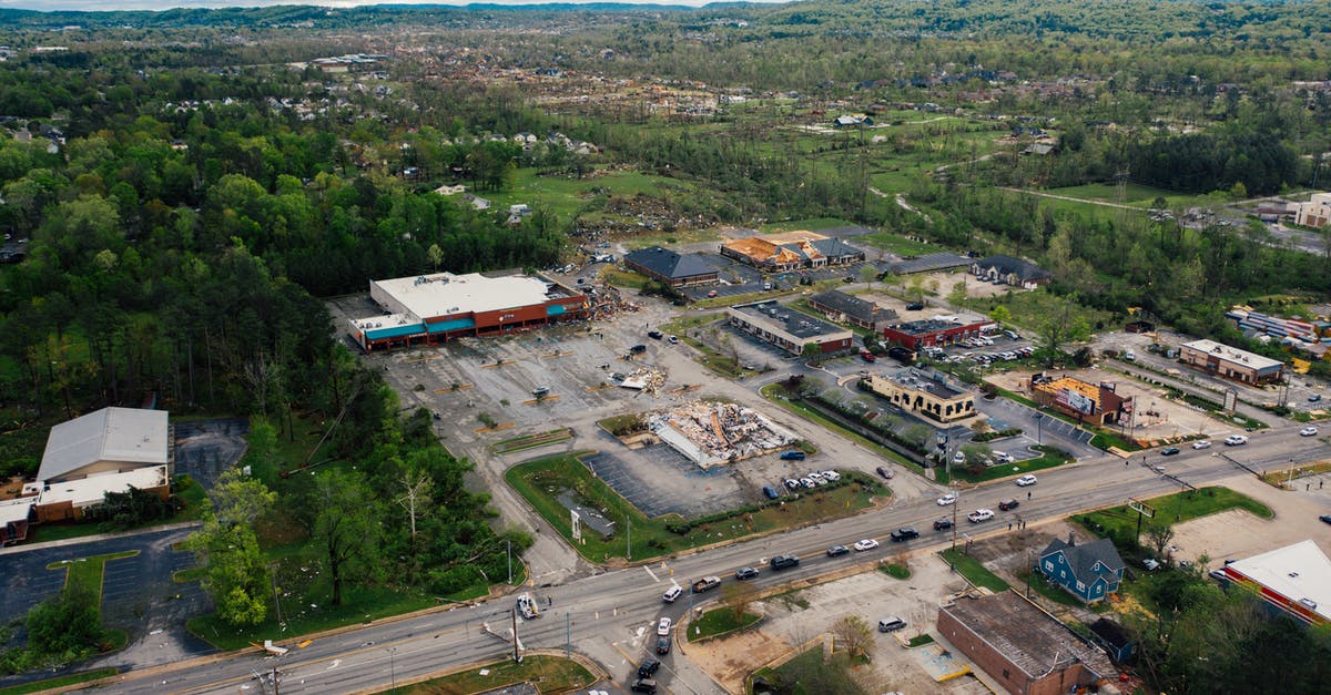 Is there a way to reconstruct destroyed outpost in Stellaris? - Aerial view of small town outpost area with low level commerce buildings surrounded with lush green trees