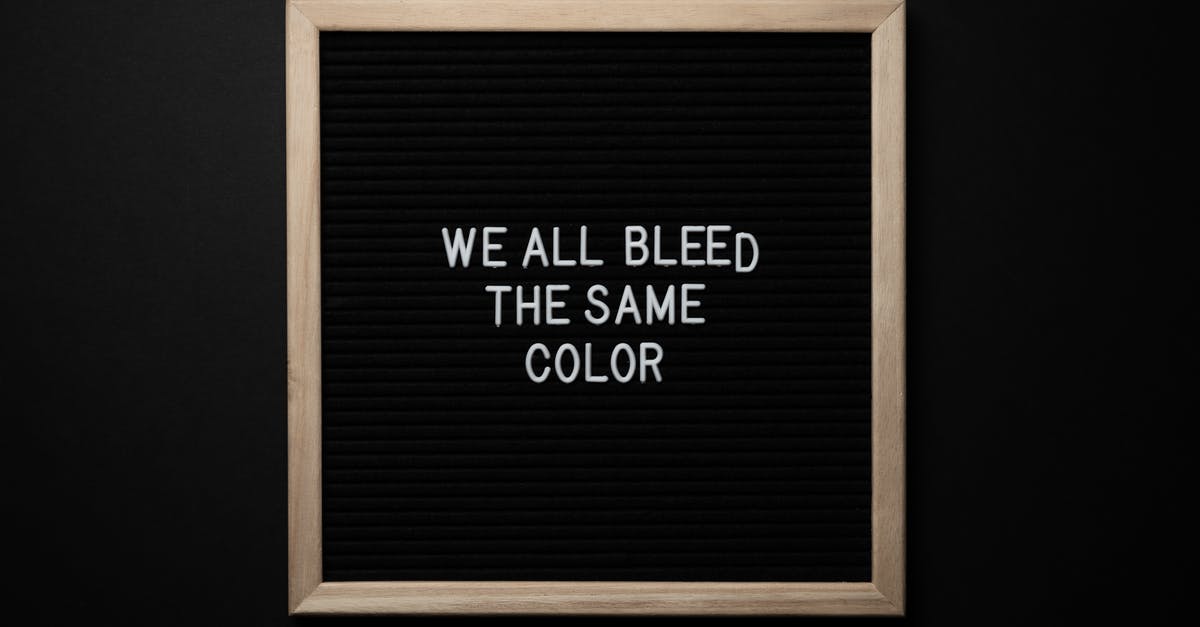 Is there a way to see all upcoming daily login rewards for Injustice on iOS? - Top view of black signboard with phrase We All Bleed Same Color on surface on black background