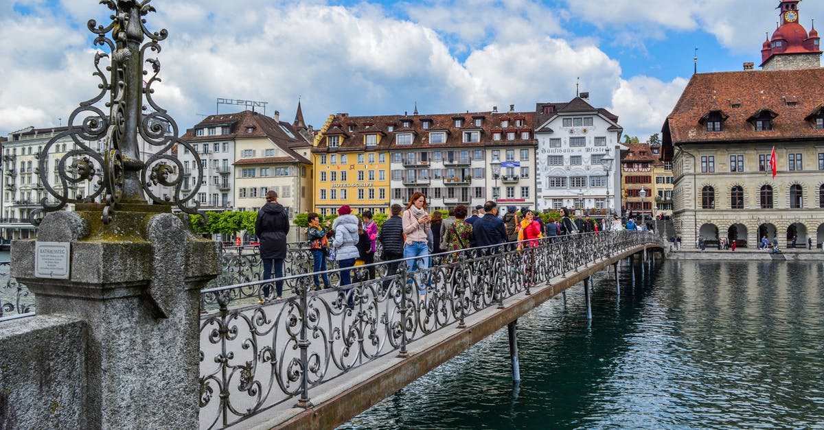 Is there a way to set separate voice options for group channel and team channel? - People walking on aged pedestrian bridge with decorative elements crossing river channel and leading to old town in daytime