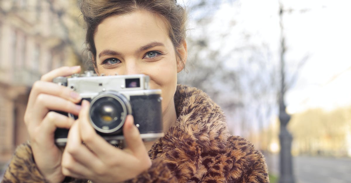 Is there a way to take picture outside would encounters? - Woman Holding Black and Gray Camera Focus Photo Is there a way to take picture outside would encounters? - Woman Holding Black and Gray Camera Focus Photo