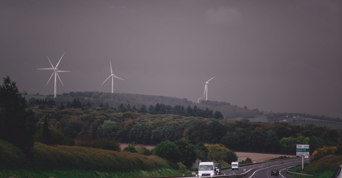 Is there a way to tell how much extra heal and shield power you have? - Asphalt highway running through grassy lush valley with modern wind turbine generators under gloomy overcast sky