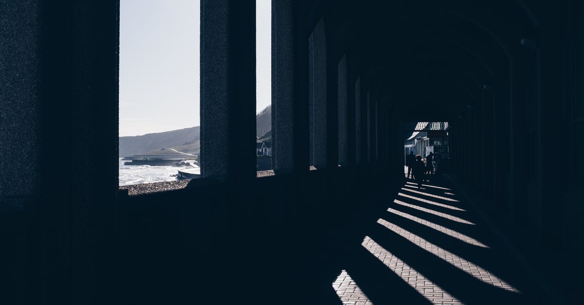 Is there a way to view all your old Miiverse drawings? - Silhouettes of faceless people walking along passage with arched windows located at seafront on sunny day