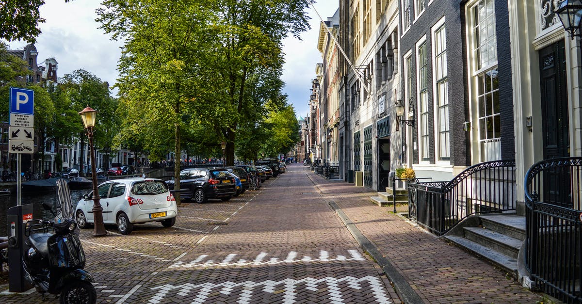 Is there a way to view all your old Miiverse drawings? - Empty paved bicycle road and sidewalk between aged residential buildings and canal in sunny morning in Amsterdam