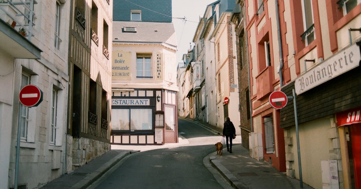 Is there an easy way to get out of a cave? - Distant man walking god on narrow walkway along road signs between aged residential houses with windows and signboards in town Is there an easy way to get out of a cave? - Distant man walking god on narrow walkway along road signs between aged residential houses with windows and signboards in town