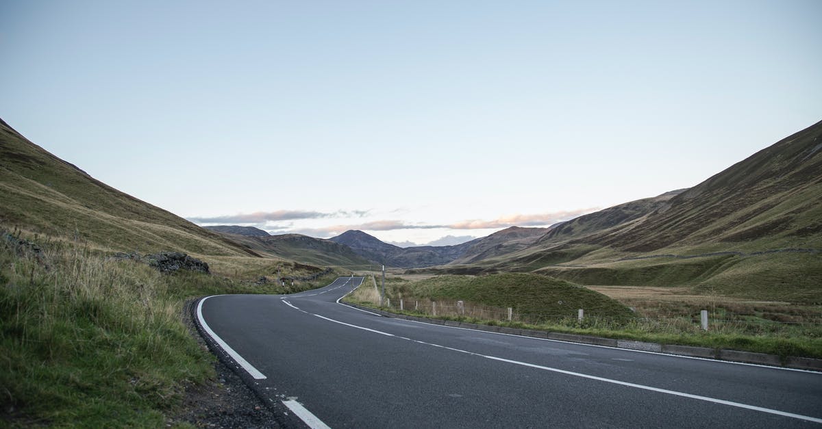 Is there an easy way to Super Swim in Wind Waker? - Empty winding asphalt roadway running through grassy hills towards mountain range under blue sky Is there an easy way to Super Swim in Wind Waker? - Empty winding asphalt roadway running through grassy hills towards mountain range under blue sky