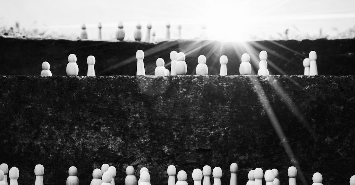 Is there any advantage to finishing battles quickly? - Black and white heap of wooden figurines placed on stairs illustrating social mobility and hierarchy on street with bright sunlight