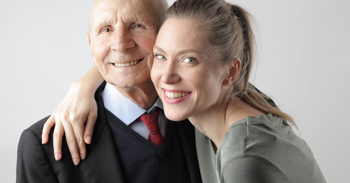 Is there any connection between parents that prevents the father from impregnating different women? - Cheerful elderly man and adult woman cuddling on white background and looking at camera Is there any connection between parents that prevents the father from impregnating different women? - Cheerful elderly man and adult woman cuddling on white background and looking at camera