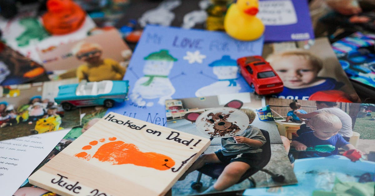 Is there any difference between card collections? - Various toys and colorful photographs of cute child on glass table at home
