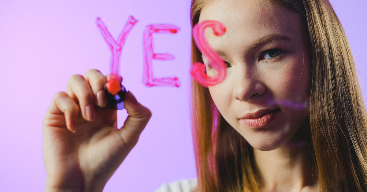 Is there any meaning behind the writing on the wall? - Girl drawing Yes word on glass