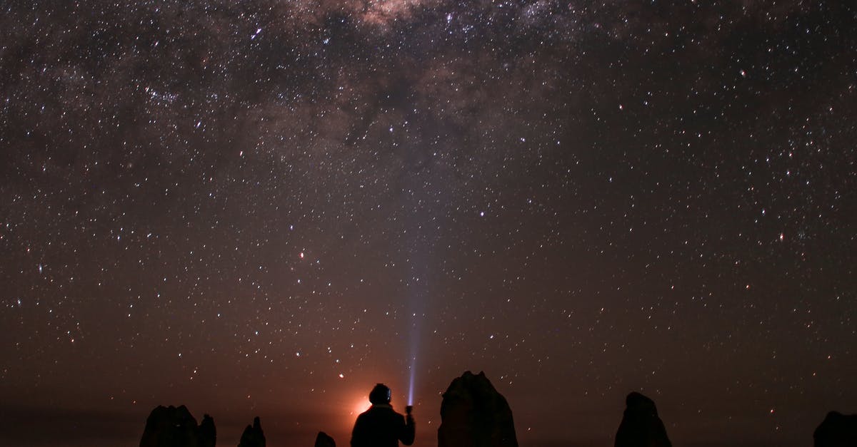 Is there any point to waving the flashlight around when exploring? - Back view silhouette of anonymous person shining flashlight at sky with glowing stars while sitting in nature at night time Is there any point to waving the flashlight around when exploring? - Back view silhouette of anonymous person shining flashlight at sky with glowing stars while sitting in nature at night time
