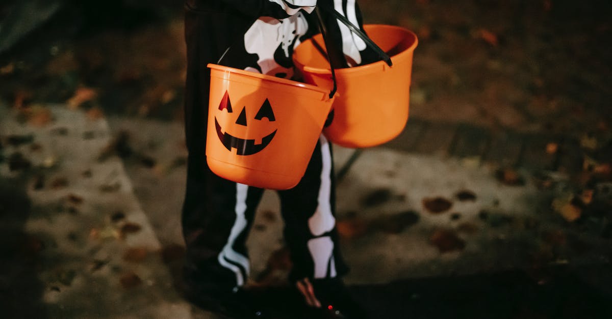 Is there any reason to carry a dead teammate? - Unrecognizable kid with Halloween buckets on pavement at night