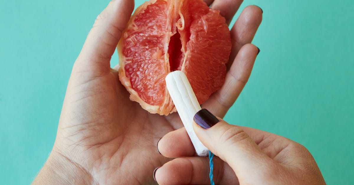 Is there any use for the hand that you find in the guest house? - From above of crop anonymous female demonstrating on sliced ripe grapefruit correct use of tampon against blue background