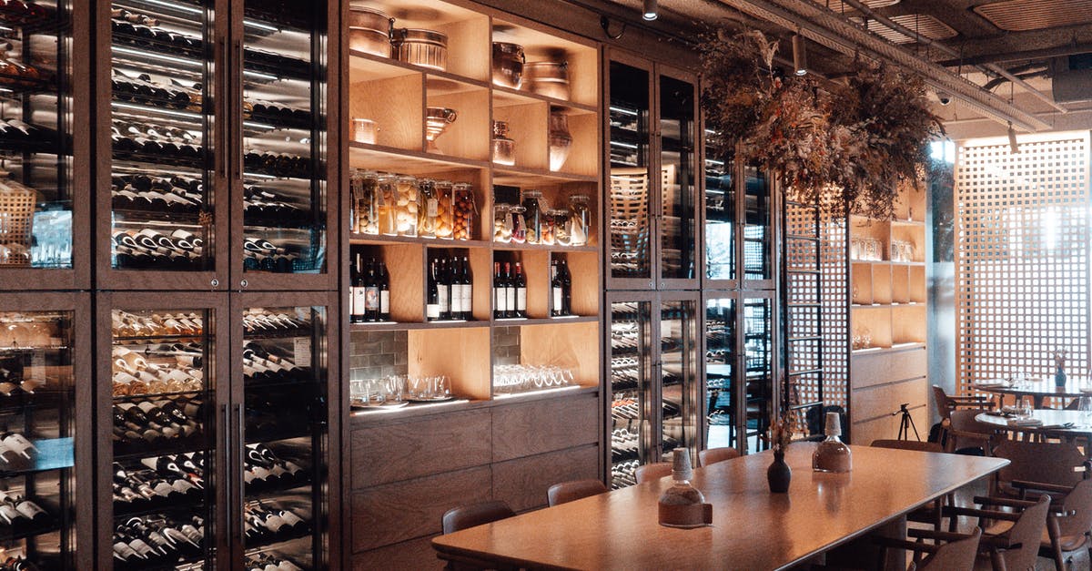 Is there any value to having quality on a lamp? - Wall with shelves with collection of assorted wine in modern restaurant with wooden furniture and creative decor