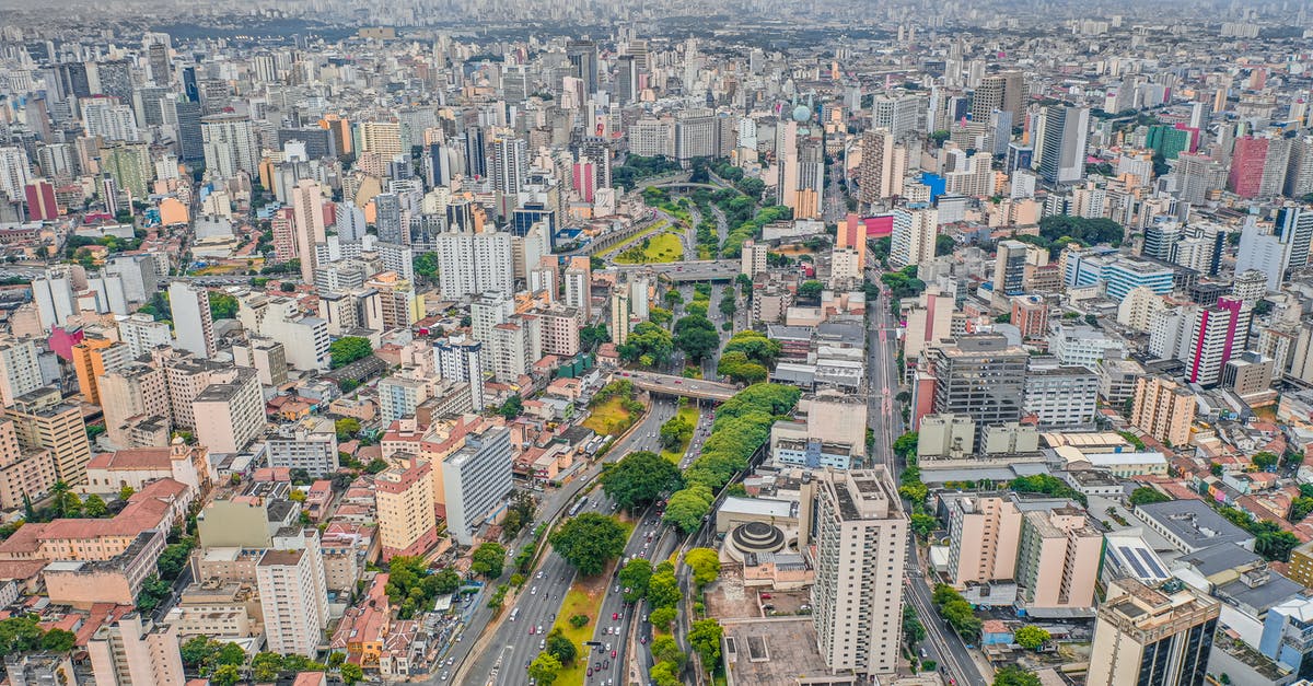Is there any way a captured but non-ceded city can grow again? - Drone view of tall contemporary residential houses located on streets of modern city with asphalt road and lush green trees Is there any way a captured but non-ceded city can grow again? - Drone view of tall contemporary residential houses located on streets of modern city with asphalt road and lush green trees