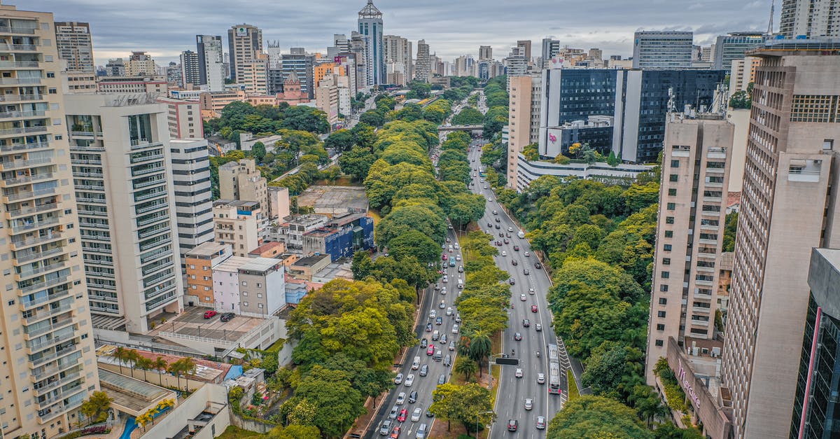 Is there any way a captured but non-ceded city can grow again? - From above of asphalt roadway between contemporary high rise residential buildings and green trees in modern city under cloudy sky in daytime