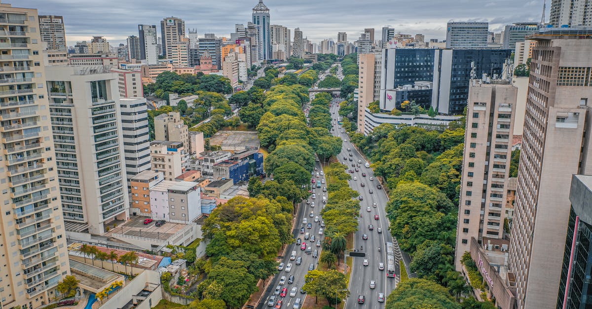 Is there any way a captured but non-ceded city can grow again? - From above of asphalt roadway between contemporary high rise residential buildings and green trees in modern city under cloudy sky in daytime Is there any way a captured but non-ceded city can grow again? - From above of asphalt roadway between contemporary high rise residential buildings and green trees in modern city under cloudy sky in daytime