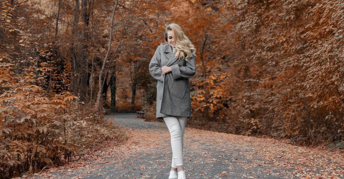 Is there any way of viewing the CD Key for a bundle on Steam? - Full body happy young female bundling up in warm cozy coat while standing on asphalt road leading through autumn forest