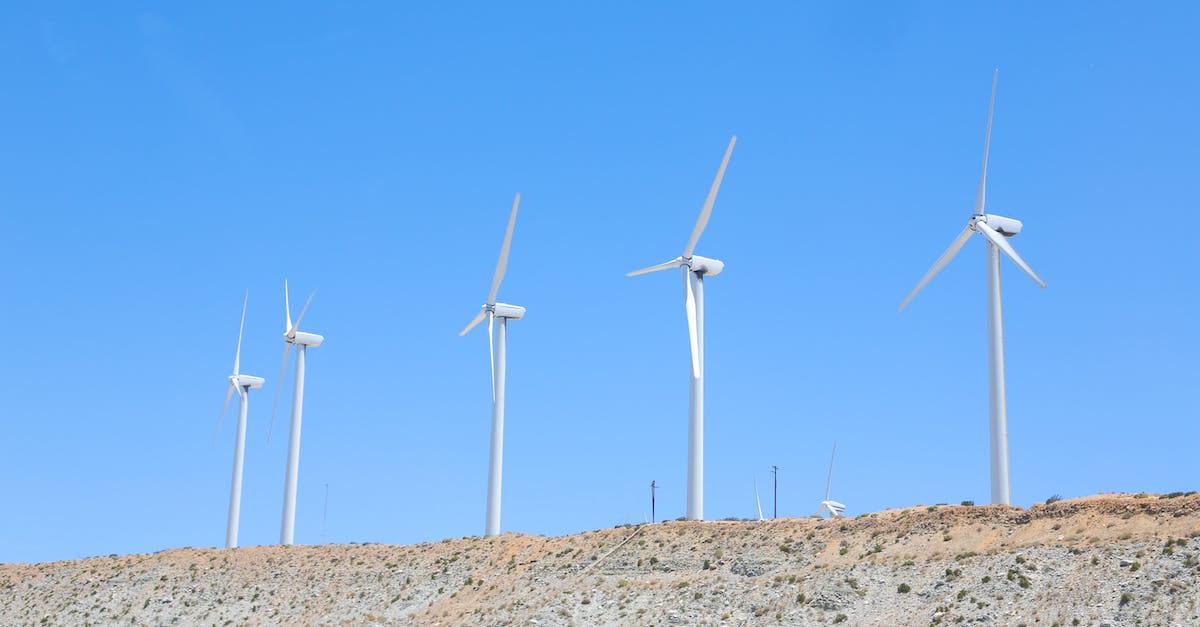 Is there any way to make the Moon generate Earth terrain in Galacticraft? - Vibrant blue cloudless sky over tall white wind turbines on slope in empty field in daytime
