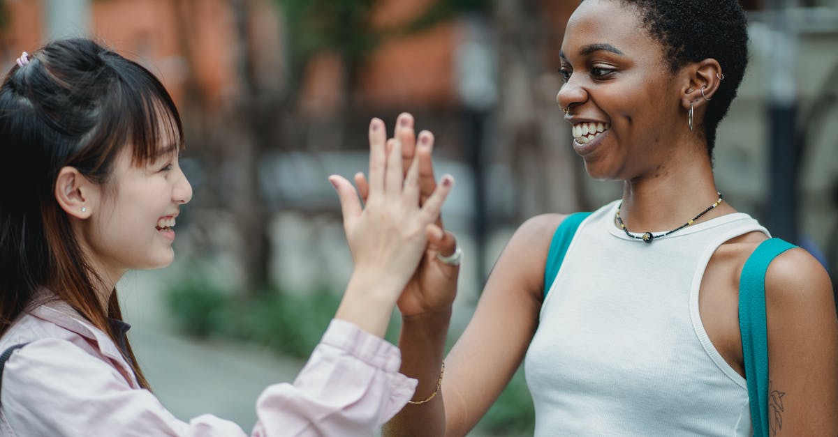 Is there no other way to remove the "7 day purchase" market ban other than spending money? - Multiracial women giving high five on street