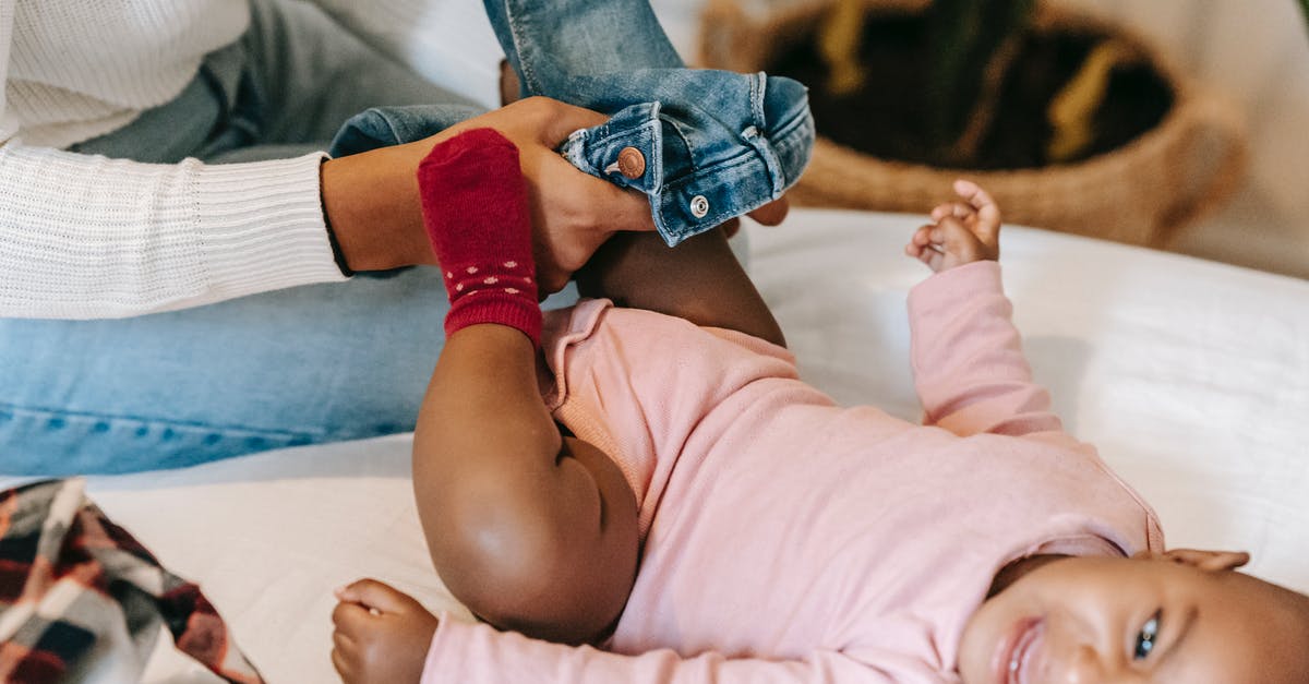 Is this scream from Majora's Mask? - High angle of crop African American mother putting jeans on baby daughter crying on changing table