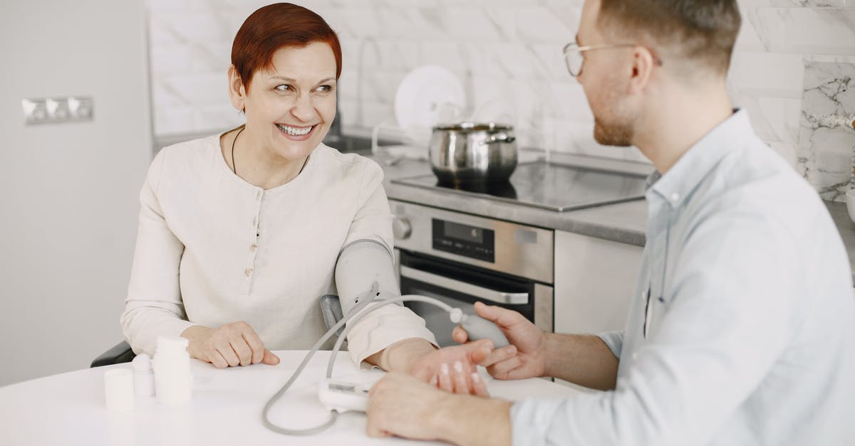 Is this supposed to be blood? - A Man Sitting at a Table Checking a Woman's Blood Pressure Is this supposed to be blood? - A Man Sitting at a Table Checking a Woman's Blood Pressure
