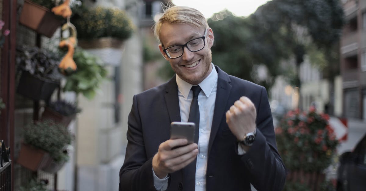 Is using Steam Achievement Manager (SAM) against Steam rules? - Cheerful male manager with mobile phone standing near flower shop in street