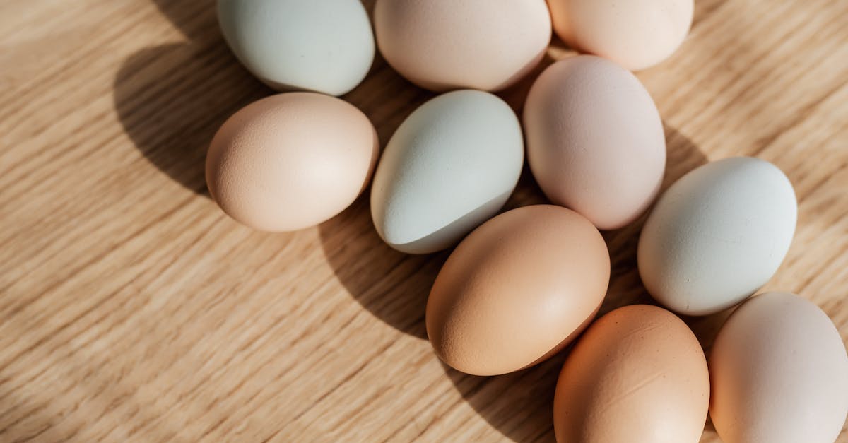 Is what is inside of an Egg Pre-Determined? - From above closeup of raw organic multicolored chicken eggs arranged on wooden surface in daylight
