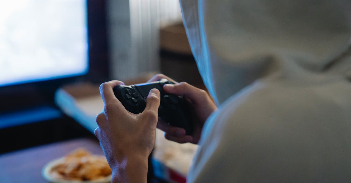 Issues reconnecting PS4 controller to console after using iPad - Crop gamer with console controller playing video game in room