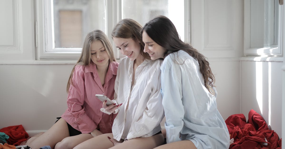 Item and ability visit on the same person - Group of young women browsing smartphone together in messy room
