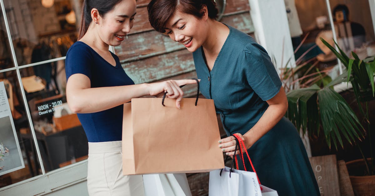 Items show up as blank spaces when trading with friend over steam - Happy ethnic female friends with shopping bags smiling while demonstrating goods to each other