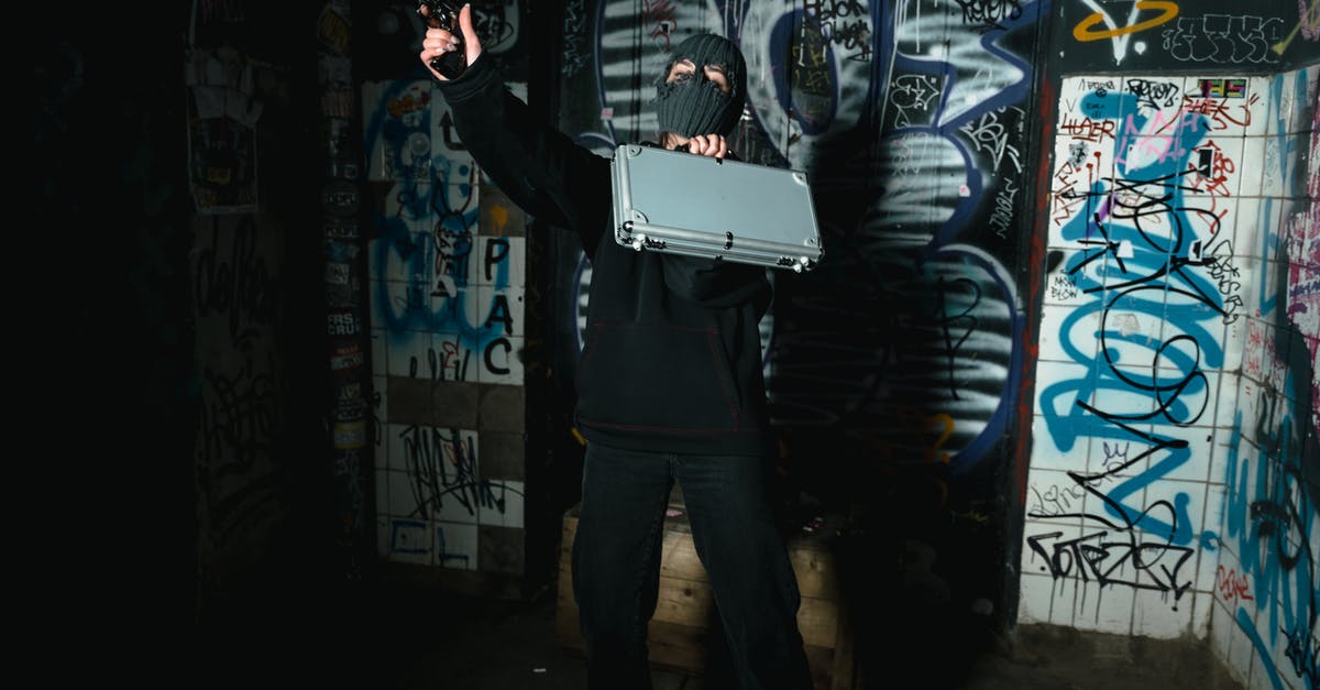 Jagged Alliance 2 1.13 weapon "M" marking - Man in Black Jacket and Black Pants Holding White Laptop Computer