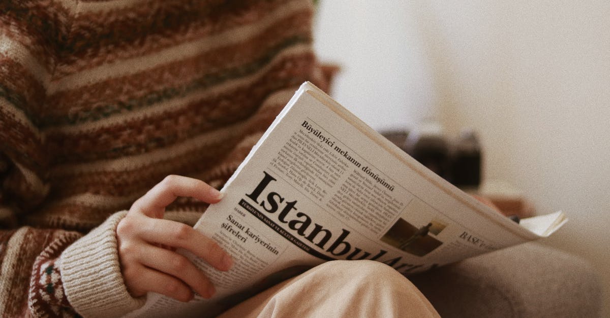 JSON at line 1 column 3 [duplicate] - Crop unrecognizable female in ornamental sweater reading newspaper article while sitting in armchair in house room