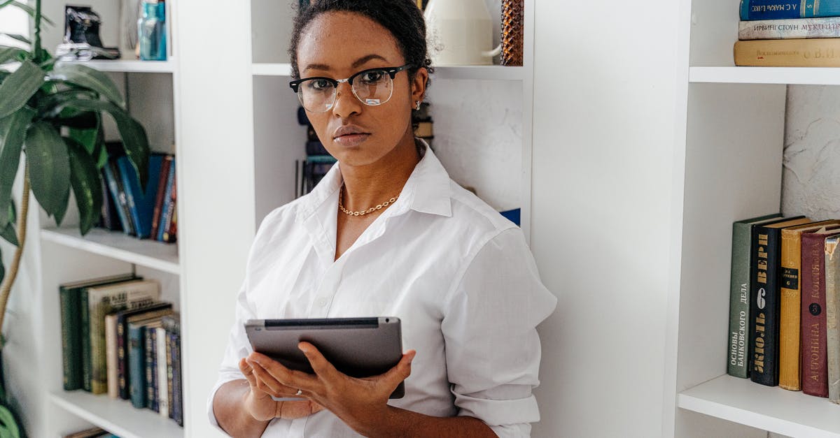 Keeping tracks of traits under research - Woman Standing by Bookcase Holding Tablet