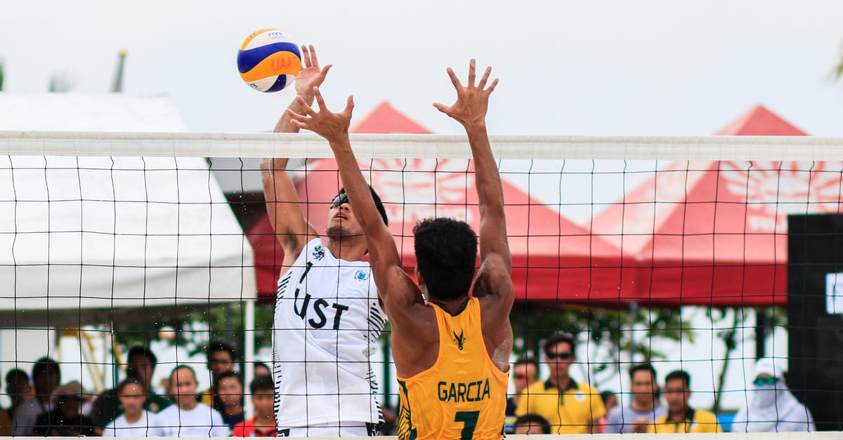 Knock a player off of a block - Two Men Playing Volleyball Near Red Canopy Knock a player off of a block - Two Men Playing Volleyball Near Red Canopy